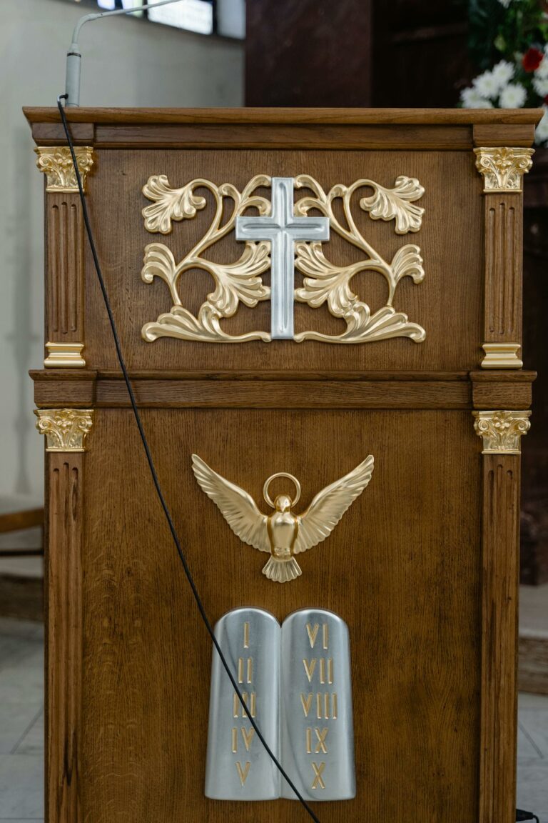 An ornate wooden pulpit featuring a cross and religious symbols, used for sermons.